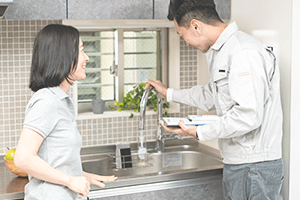 女性に説明する作業服姿の男性